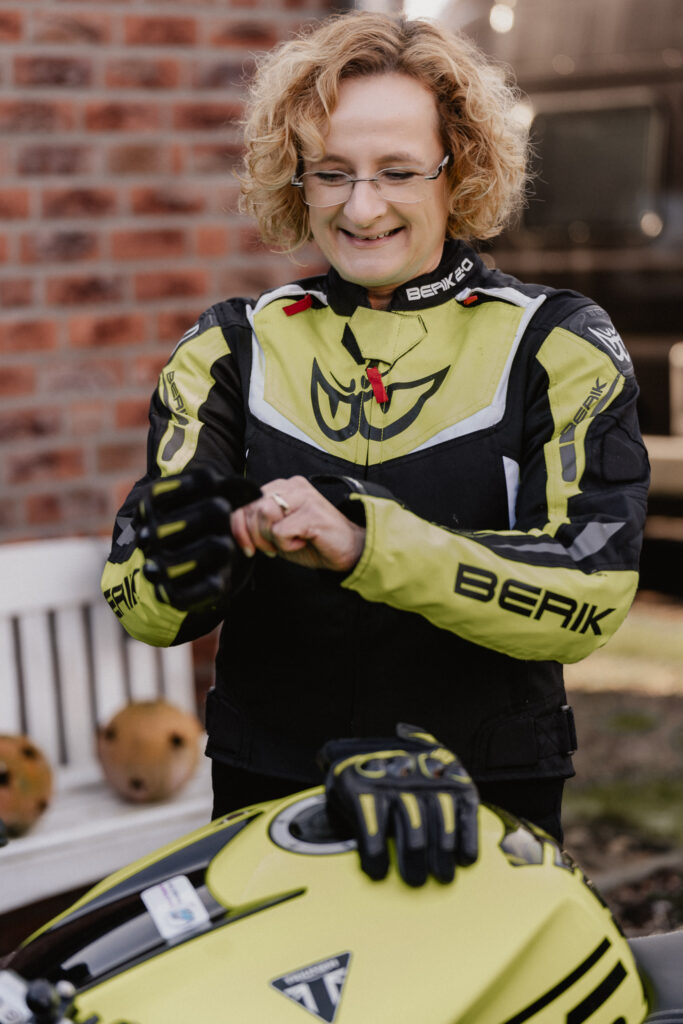 Motrorradcoach zieht Motrorradhandschuhe an