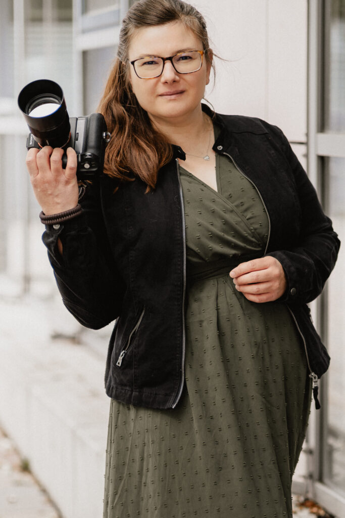 Fotografin für Personal Brand und Portraitfotografie mit Kamera in der Hand