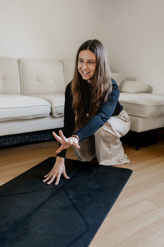 Yogalerhrerin rollt Yogamatte aus